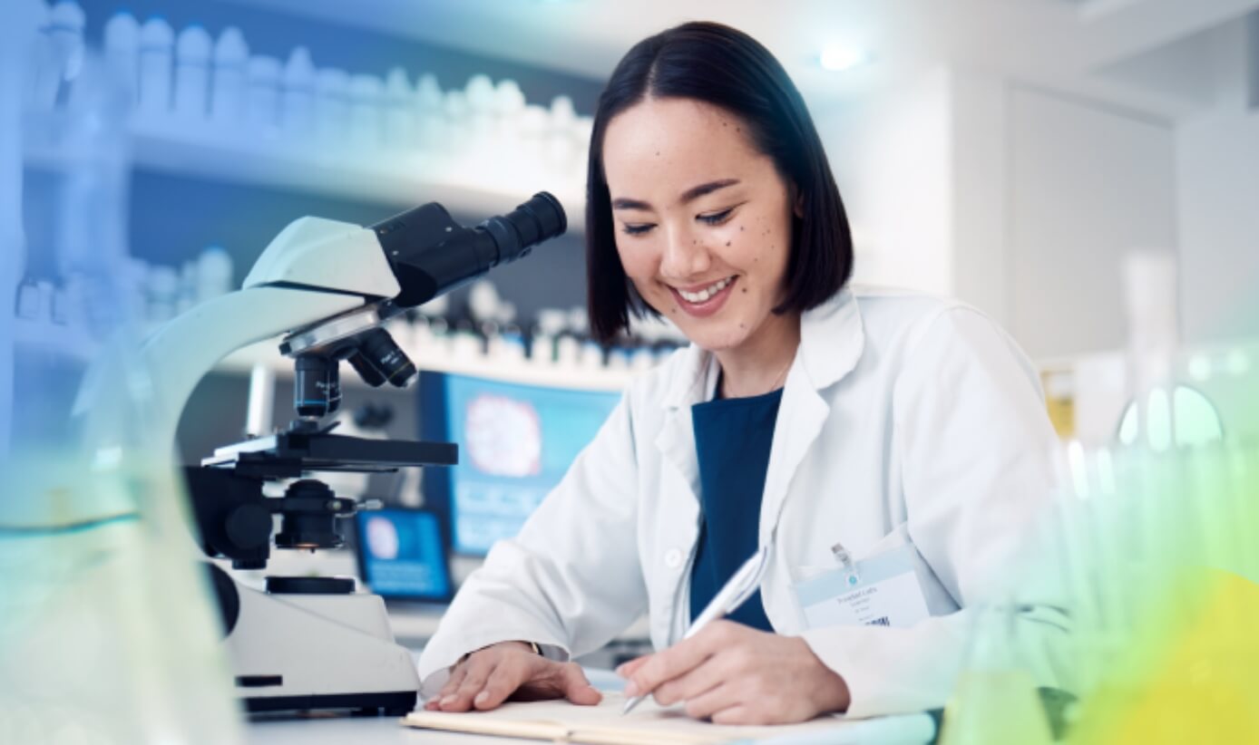 Woman writing down notes in a laboratory with a microscope